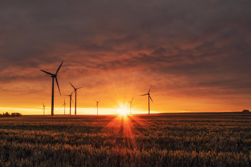 a wind power turbine surrounded by clear blue sky